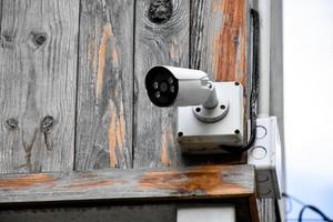 IP CCTV CAMERA installed on wooden pole outside of the house to do the security by monitoring through moblie phone and other smart devices to save property and human life. photo