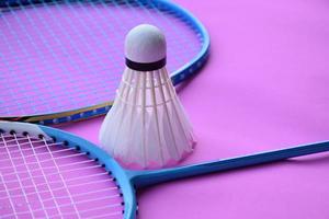 Cream white badminton shuttlecock and racket on floor in indoor badminton court, copy space, soft and selective focus on shuttlecocks. photo