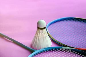 Cream white badminton shuttlecock and racket on floor in indoor badminton court, copy space, soft and selective focus on shuttlecocks. photo