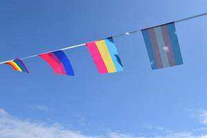 Las banderas lgbtq se colgaron en un cable contra el cielo azul en un día soleado, enfoque suave y selectivo, concepto para celebraciones de género lgbtq en el mes del orgullo en todo el mundo. foto