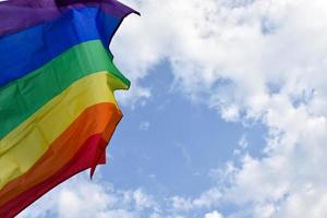 Bandera lgbtq con fondo nublado y cielo azul, enfoque suave y selectivo, fondo borroso nublado y cielo azul, concepto para celebraciones de género lgbtq en el mes del orgullo. foto