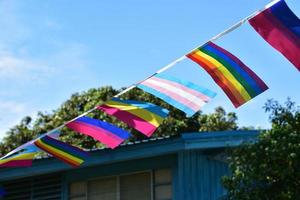 Lgbtq flags were hung on wire to decorate outside balcony of restaurant, soft and selective focus, concept for LGBTQ plus gender celebrations in pride month around the world. photo