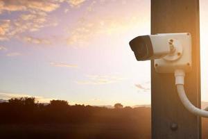 IP CCTV CAMERA installed on wooden pole outside of the house to do the security by monitoring through moblie phone and other smart devices to save property and human life. photo