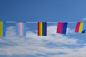 Las banderas lgbtq se colgaron en un cable contra el cielo azul en un día soleado, enfoque suave y selectivo, concepto para celebraciones de género lgbtq en el mes del orgullo en todo el mundo. foto