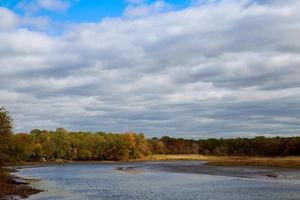 autumn landscape of river and trees without leaves blue sky clouds on a sunny day photo