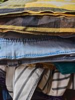 a neatly arranged pile of various neat clothes and pants after ironing. photo