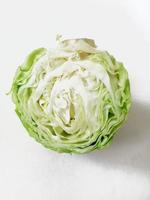 half of green cabbage on white background photo