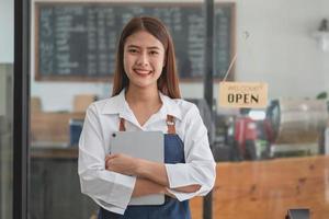 Portrait of a woman, a coffee shop business owner who is smiling beautifully and opening a coffee shop that is her own business, SME concept. photo