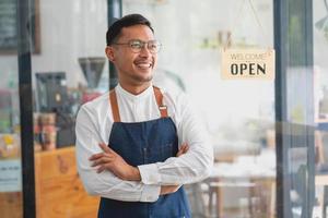 retrato de un hombre, dueño de un negocio de cafetería que sonríe hermosamente y abre una cafetería que es su propio negocio, concepto de pyme. foto