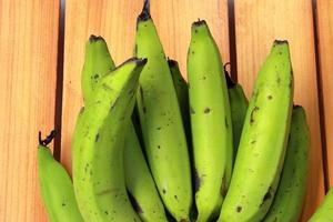 Banana on wooden background. Healthful red banana collection. Ripe bunch of banana photo