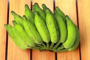 Banana on wooden background. Healthful red banana collection. Ripe bunch of banana photo