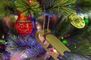 Colorful Christmas decorations on a fir tree with blurred lights. photo