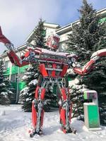 Red iron metal big strong dangerous fantastic, futuristic humanoid robot, transformer from a car with hands and head in winter Minsk, Belarus, January 15, 2019 photo