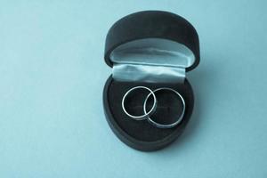 una hermosa caja de regalo festiva roja terciopelo para dos compromisos, anillos de boda con preciosos anillos redondos de oro preciosos. concepto propuesta de matrimonio, boda, compromiso foto