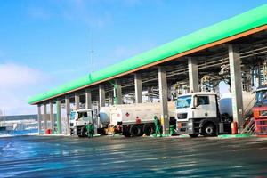 gran gasolinera industrial verde para repostar vehículos, camiones y tanques con combustible, gasolina y diésel en invierno foto