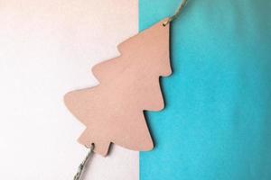 Festive New Year's Christmas beautiful bright multi-colored joyful blue and white background with a small toy wooden homemade cute Christmas tree. Flat lay. Top view. Holiday decorations photo