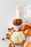 alimentos proteicos sobre un fondo blanco - requesón, huevos, nueces. un conjunto de alimentos saludables para una dieta equilibrada.