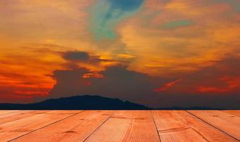 brown wooden board over beautiful sunset with mountain photo