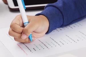 mano de estudiante tomando examen de inglés en clase foto