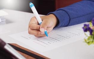 mano de estudiante tomando examen de inglés en clase foto