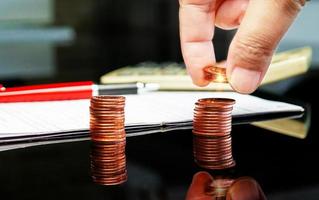 hand holding coins over row of coin photo