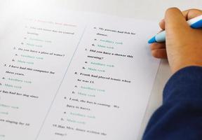 mano de estudiante tomando examen de inglés en clase foto