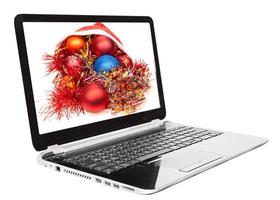 bodegón de navidad con bolas rojas y azules en la computadora portátil foto