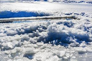 broken ice near hole in frozen lake photo