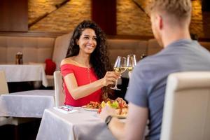 pareja joven almorzando con vino blanco en el restaurante