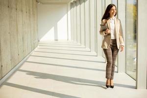 Young businesswoman walking on modern office hallway photo