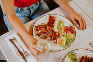 Young couple having lunch with white wine in the restaurant photo