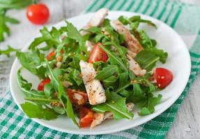 Fresh salad with chicken breast, arugula and tomato photo