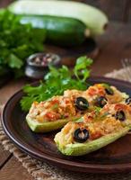 Stuffed zucchini with chicken, tomatoes and olives with cheese crust photo