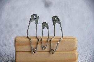 Model safety pin of parent and children sitting on wooden table with customizable space for text or ideas. Family concept photo