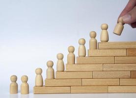 Wooden people figure on top of wooden blocks. Goal achievement, business growth and career progression. photo