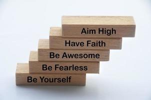 Words of motivation on wooden blocks - Aim high, have faith, be awesome, be fearless, be yourself photo
