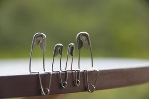 Model safety pin of family sitting on wooden table with blurred nature background. Copy space and family concept photo