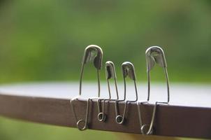 Model safety pin of family sitting on wooden table with blurred nature background. Copy space and family concept photo