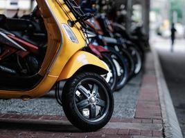 A yellow scooter parked on the pavement in Kuala Lumpur photo