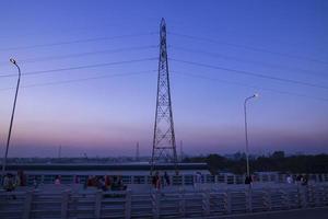 torres eléctricas de alto voltaje con paisajes coloridos después del atardecer foto