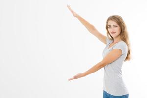 Portrait of smiling young blonde caucasian woman wearing summer t shirt pointing at copy space by hands isolated on white template and blank background. Advertising plase photo