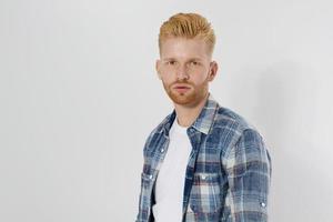 Young redheaded man with red beard in blank summer tshirt, plaid shirt isolated on white background. Unshaven confident serious male enterpreneur. Copy space. Mock up. Student guy photo