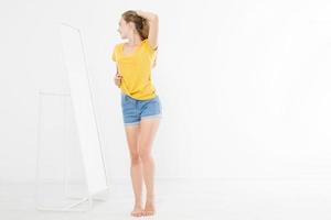 Girl dress up and looking in mirror. Shopping and weight loss concept. Copy space. Blank template background. photo