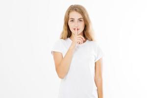 Shhh sign. Young woman showing shh gesture to keep a silent. Girl in template white t shirt keep a secret. Quiet place and silence time. Copy space photo