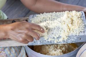 mano de mujer rascando una papa para cocinar comida. foto