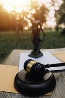 Business and lawyers discussing contract papers with brass scale on desk in office. Law, legal services, advice, justice and law concept picture with film grain effect photo