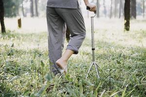 young asian physical therapist working with senior woman on walking with a walker photo