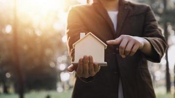 House model with real estate agent and customer discussing for contract to buy house, insurance or loan real estate background. photo