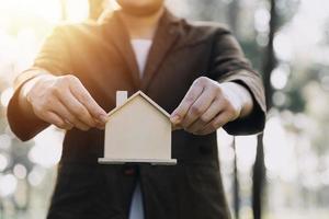 House model with real estate agent and customer discussing for contract to buy house, insurance or loan real estate background. photo