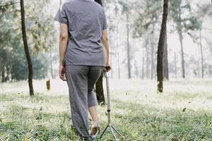 young asian physical therapist working with senior woman on walking with a walker photo